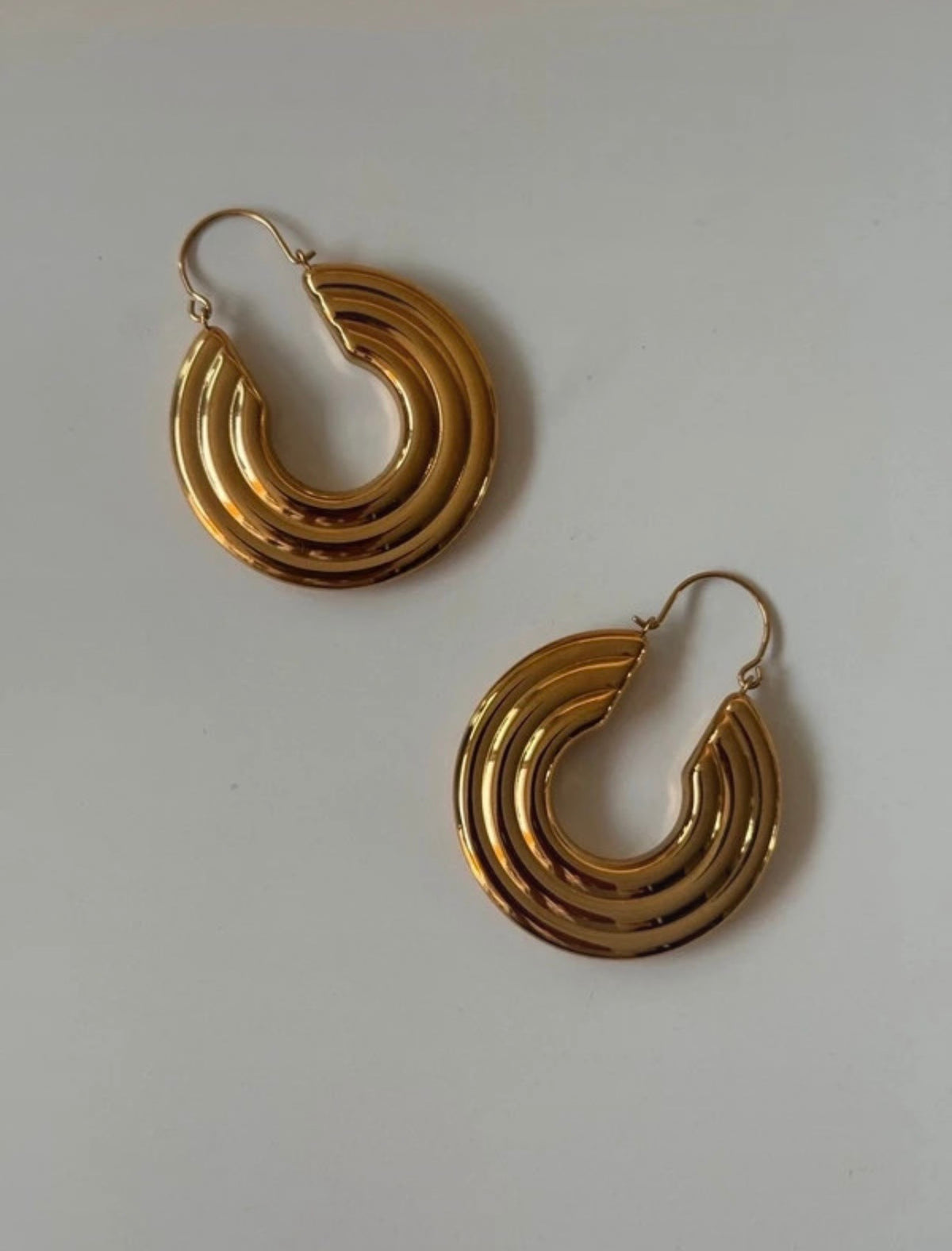 Pendientes Rythme Art Déco dorados, vista cercana