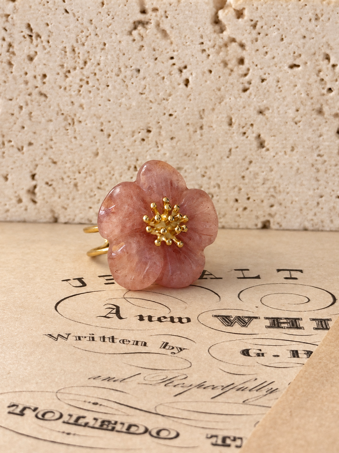 Detalle del anillo rosa empolvado sobre hojas de música
