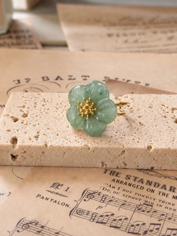 Anillo de flor verde salvia con pétalos tallados sobre piedra
