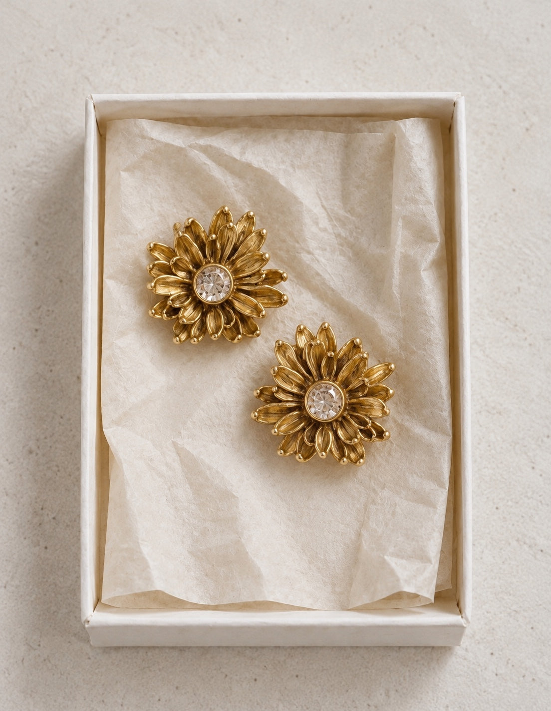 Pendientes Crisantemi dorados con cristal central en caja de joyería
