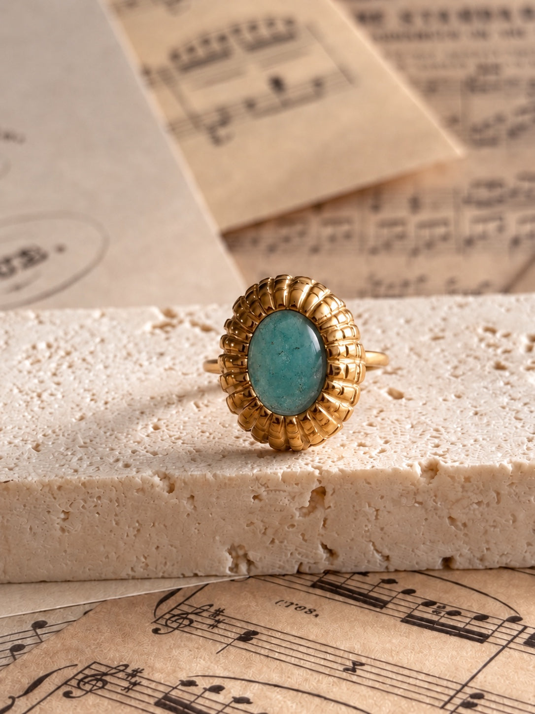 Anillo Esclarmonde con amazonita, vista frontal sobre piedra y partituras