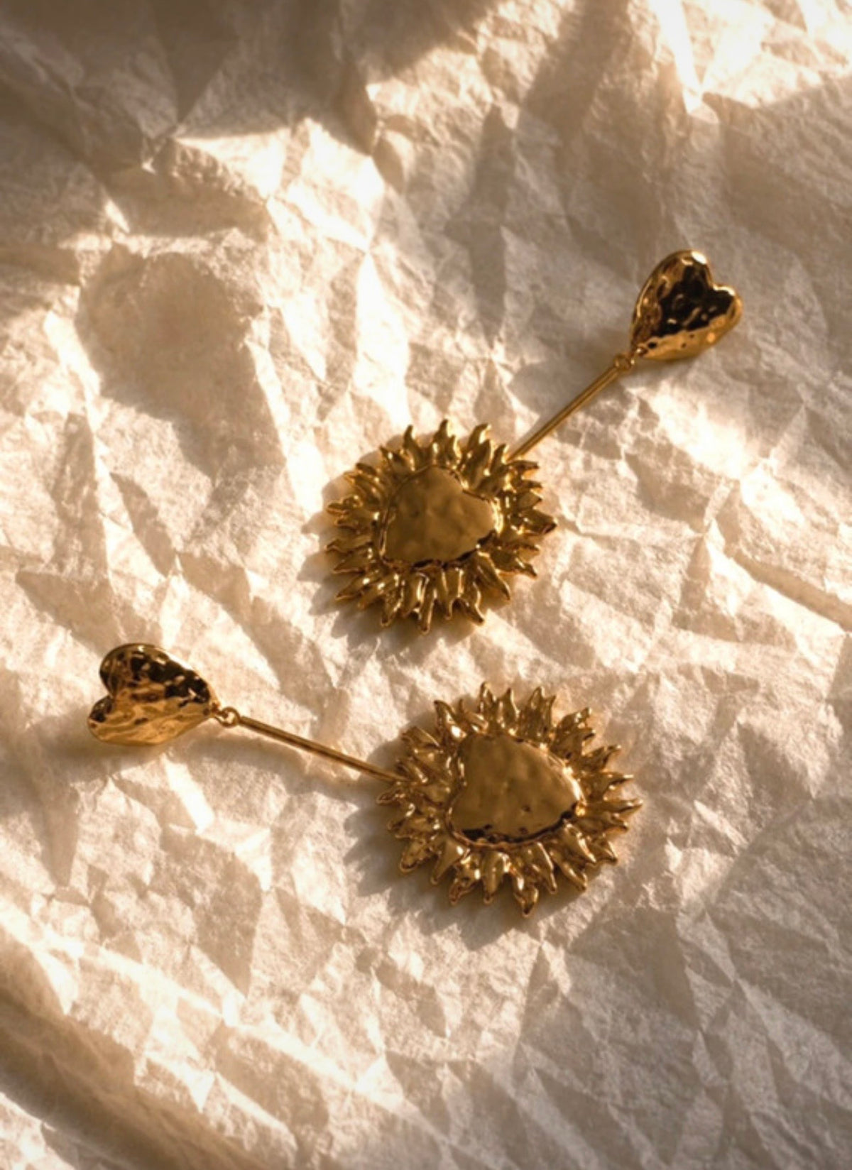 Pendientes Isolda dorados en composición editorial