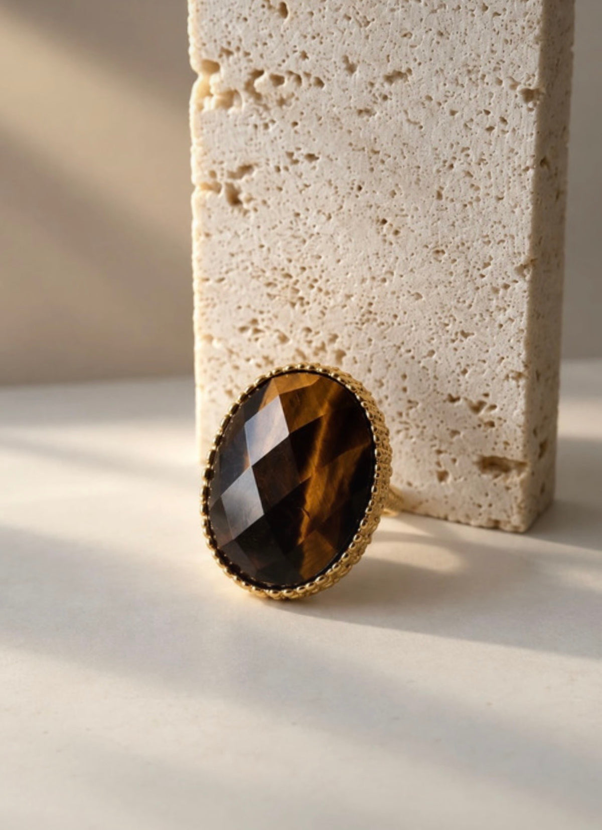 Anillo L’Œil du fauve con ojo de tigre, frontal junto a bloque de piedra