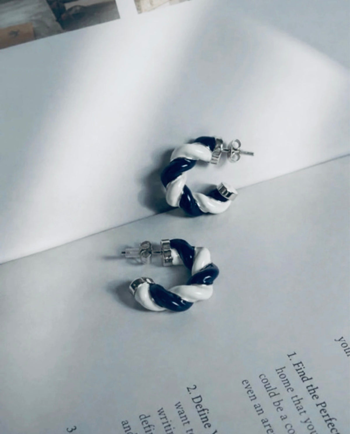 Pendientes vintage trenzados azul marino y blanco en composición editorial