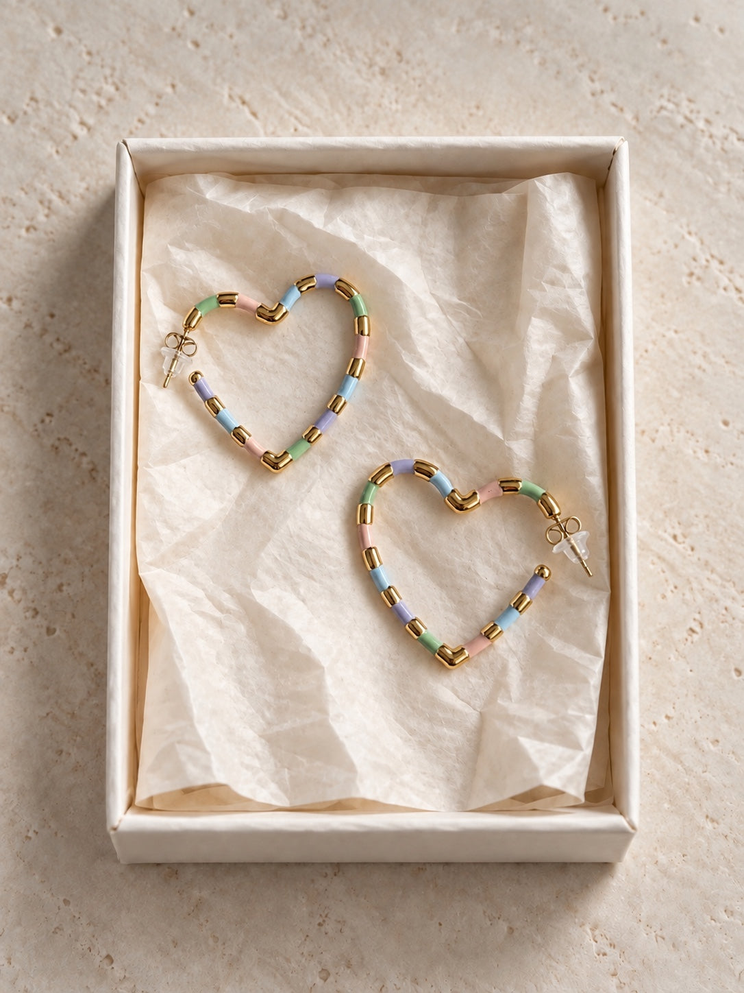 Pendientes de corazón en tonos pastel dentro de su caja
